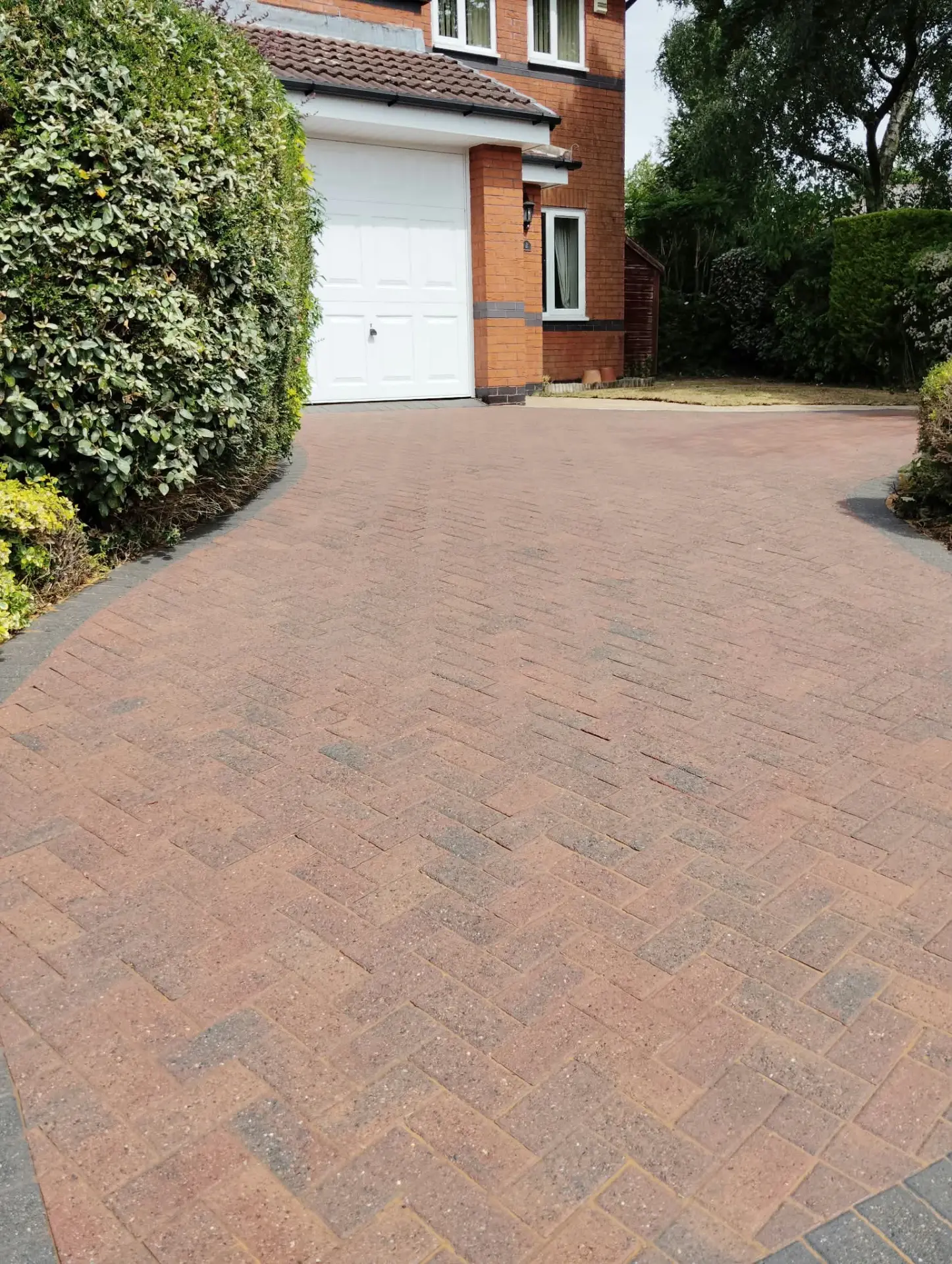 Herringbone block paving driveway restored to its original colour after cleaning