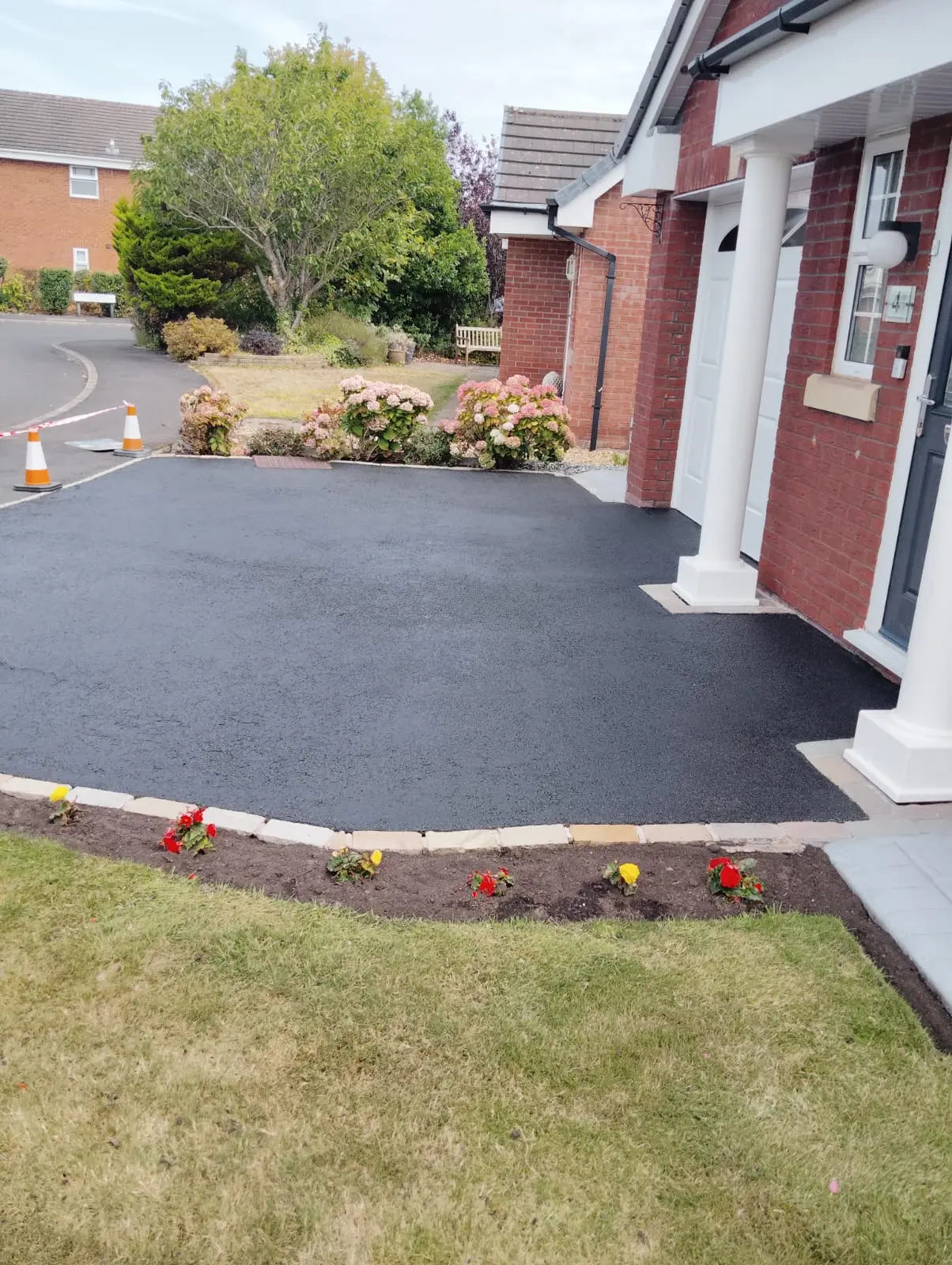Restored tarmac driveway coned off to cure after sealing