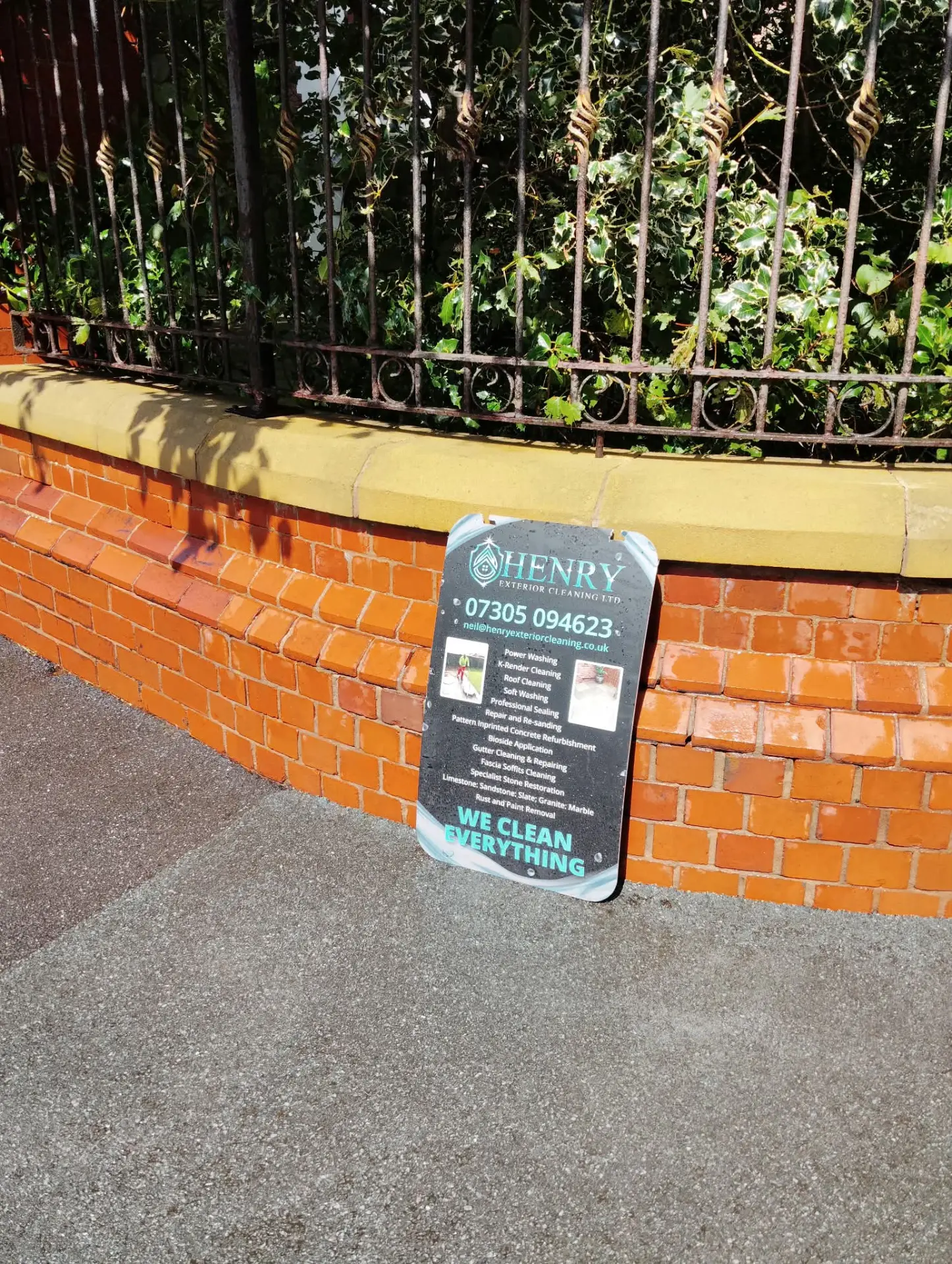 Close view of acid cleaned brickwork and restored yellow stone coping beneath iron railings