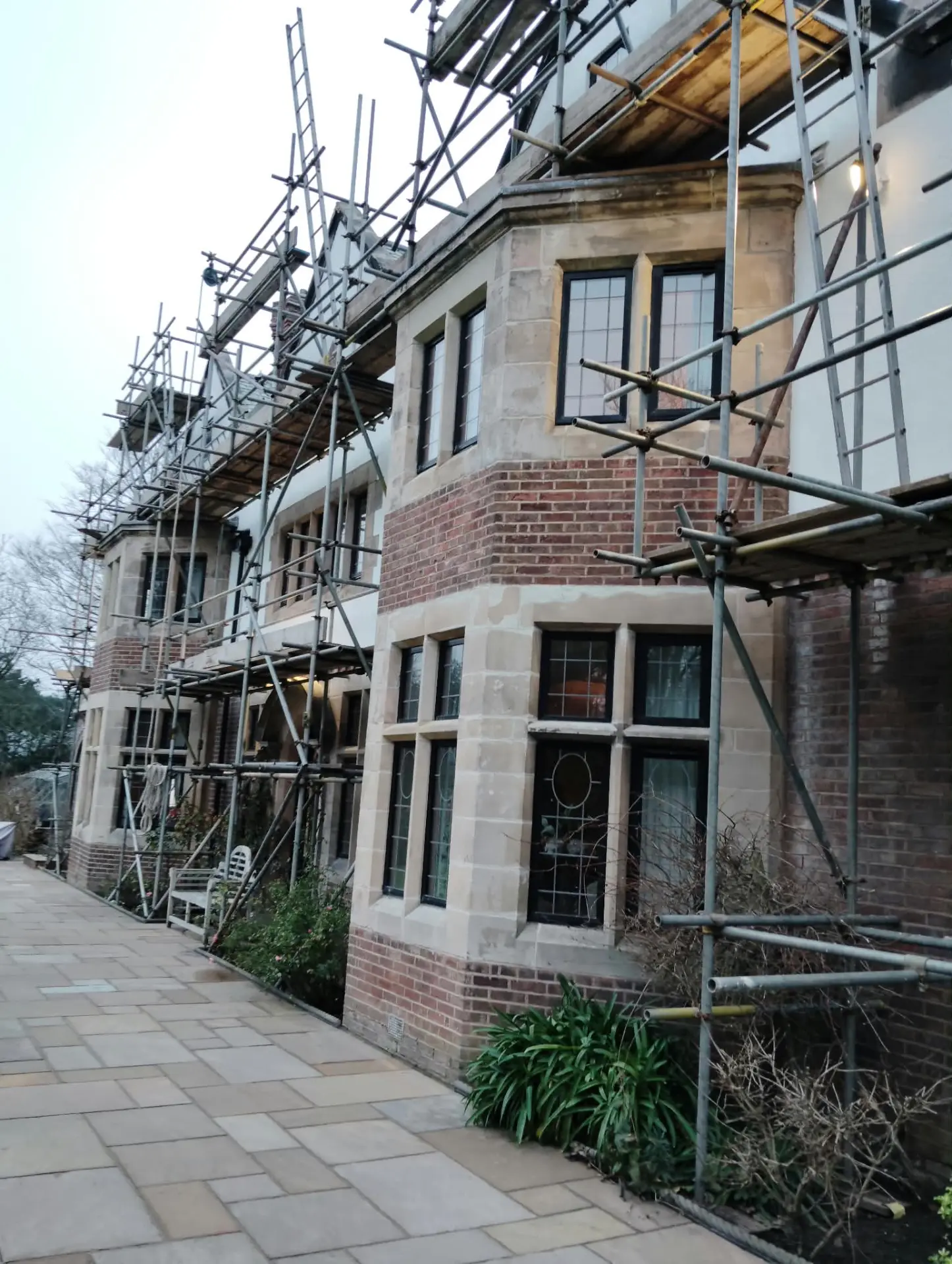 Scaffolded period property mid conservation clean, showing restored sandstone bays