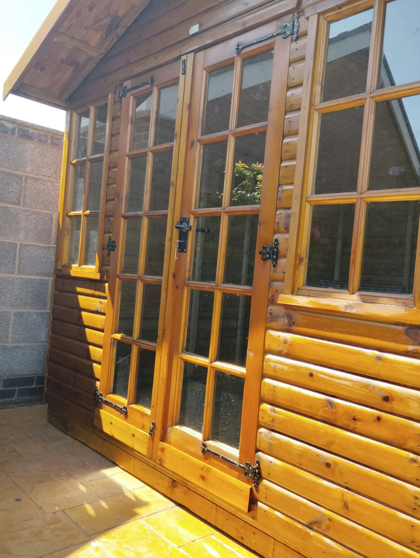 Close up of freshly treated summerhouse French doors and glazing bars after woodcare