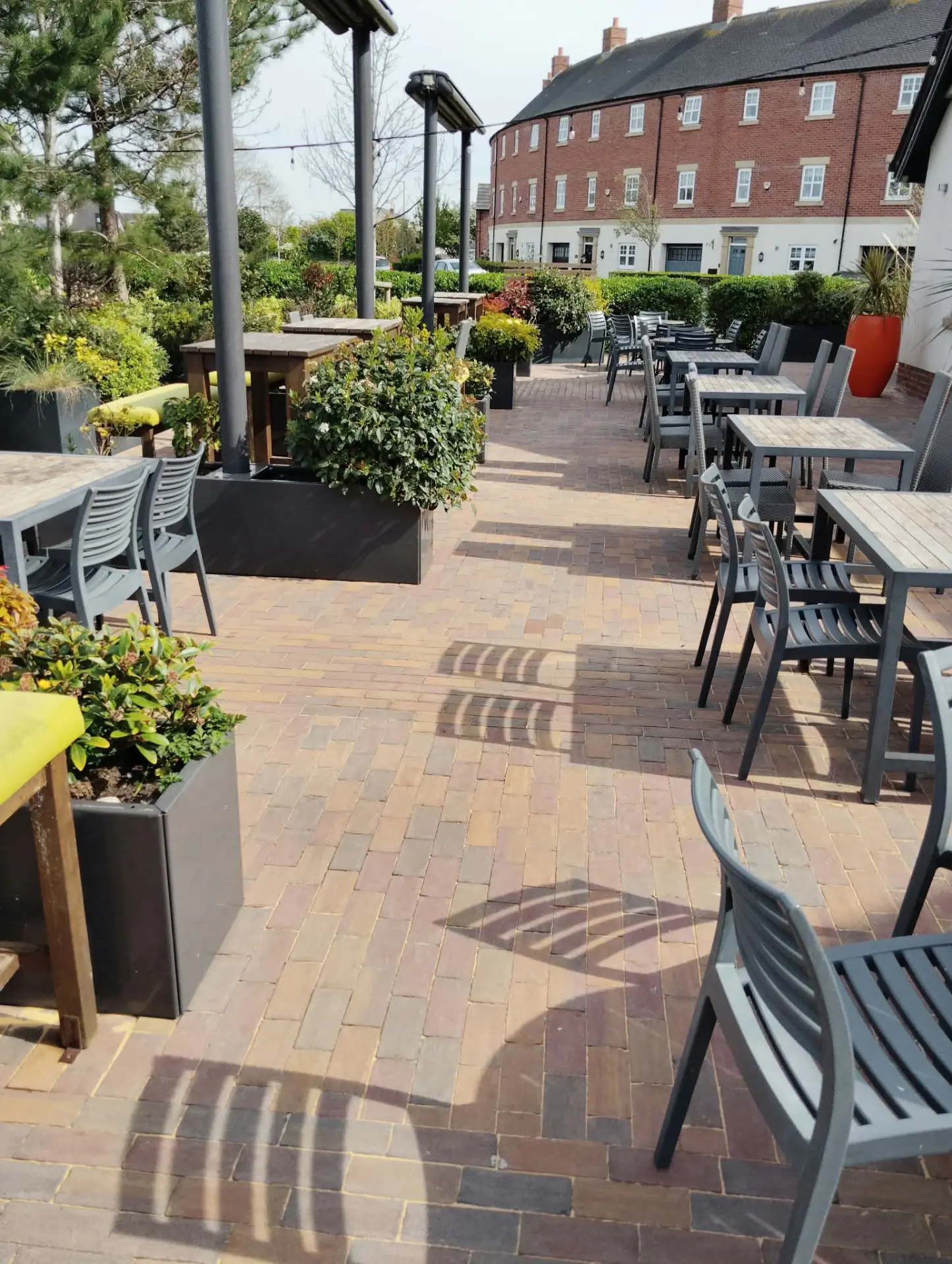 Cleaned clay paved terrace with tables and planters after restoration