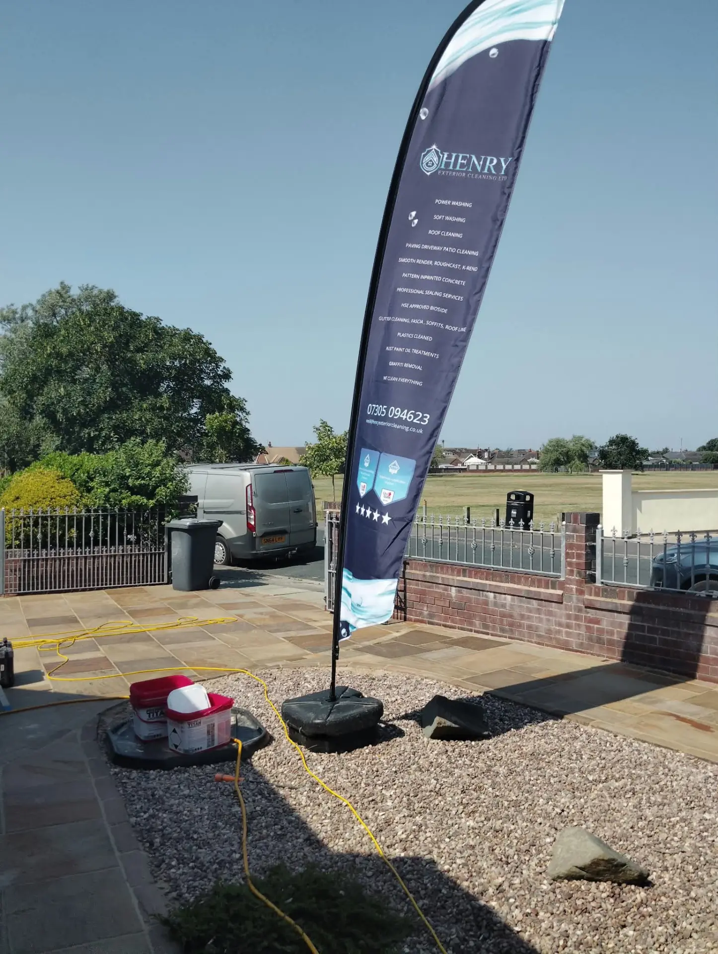 Henry Exterior Cleaning flag beside a restored sandstone patio during sealing
