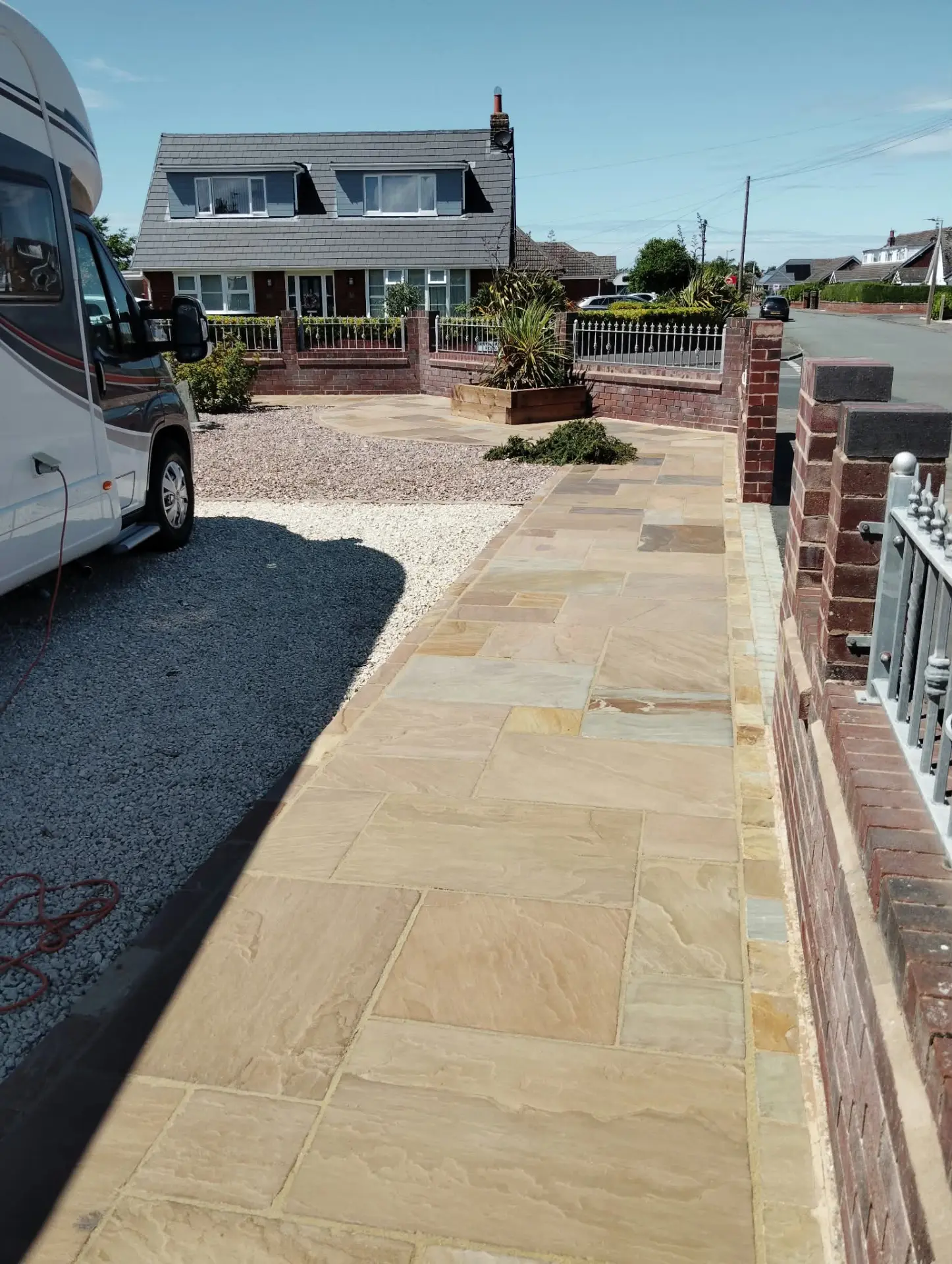 Long sandstone path restored alongside a gravel driveway and front garden